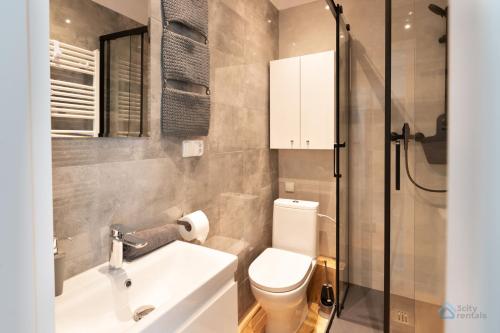 uma casa de banho com um WC, um lavatório e um chuveiro em Uroda Morza by 3City Rentals em Gdynia