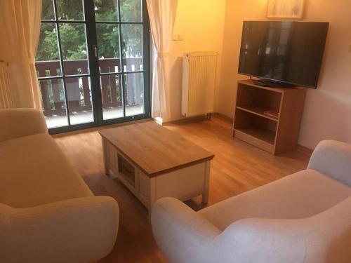 ein Wohnzimmer mit zwei Stühlen und einem Flachbildfernseher in der Unterkunft Holiday Home Holiday Hill 63 by Interhome in Lauterwasser