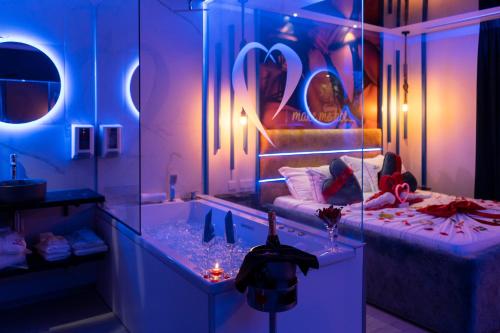 a room with two girls sitting on a bed and a tub at Motel Emoções in Nogueira da Regedoura
