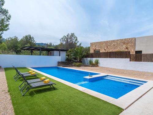 een zwembad in een achtertuin met een bank en gras bij Villa Villa Carme by Interhome in Colonia de Sant Pere