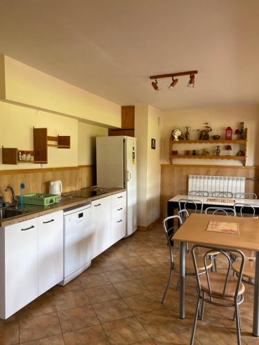 a kitchen with white cabinets and a table at Willa Światowid in Rabka-Zdrój