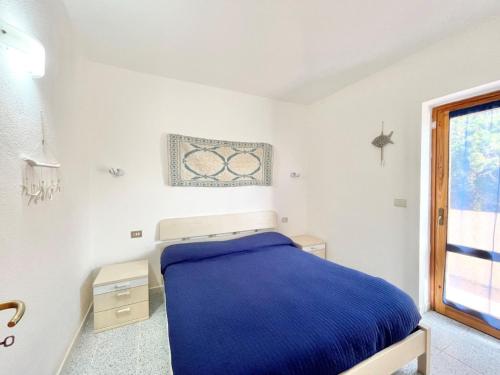 Un dormitorio con una cama azul y una ventana en Holiday Home Turriga by Interhome, en Aglientu