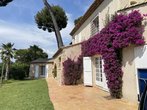 une maison avec des fleurs violettes sur son côté dans l'établissement Magnifique Villa de prestige Antibes/Juan-les-Pins, à Antibes
