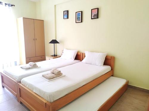 a bedroom with two beds with towels on them at Central Apartments in Paralia Dionysiou