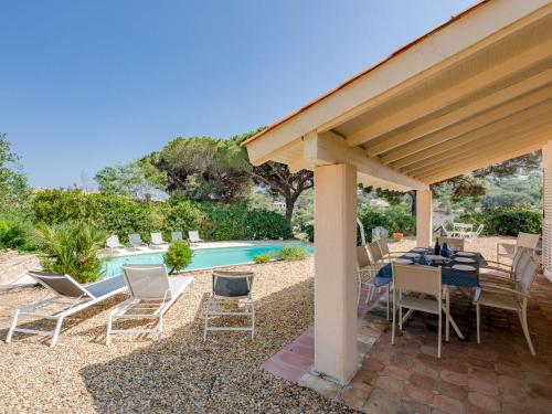 un patio con mesa, sillas y piscina en Holiday Home Cascabelle by Interhome, en Sainte-Maxime