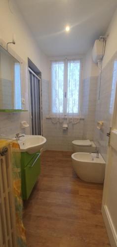 uma casa de banho com 2 lavatórios, uma banheira e um WC. em CASA MAREA Appartamento 1 em Grottammare