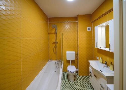 ein Badezimmer mit Badewanne, Toilette und Waschbecken in der Unterkunft Apartament Laur in Gura Humorului