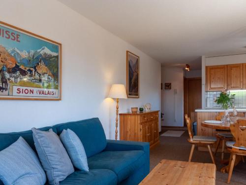 a living room with a blue couch and a table at Apartment Les Crêtes 1-4 by Interhome in Veysonnaz