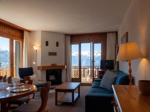 a living room with a blue couch and a table at Apartment Les Crêtes 1-4 by Interhome in Veysonnaz