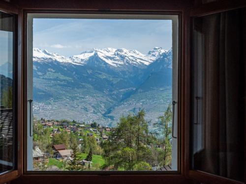 a view of a mountain range from a window at Chalet Dolce Cabane by Interhome in Nendaz