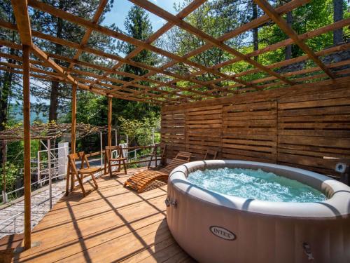 a hot tub on a deck with a pergola at Chalet Nina by Interhome in Lič