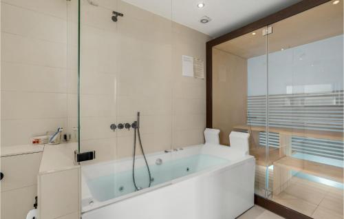 a bathroom with a tub and a glass shower at 3 Bedroom Lovely Home In Haderslev in Kelstrup