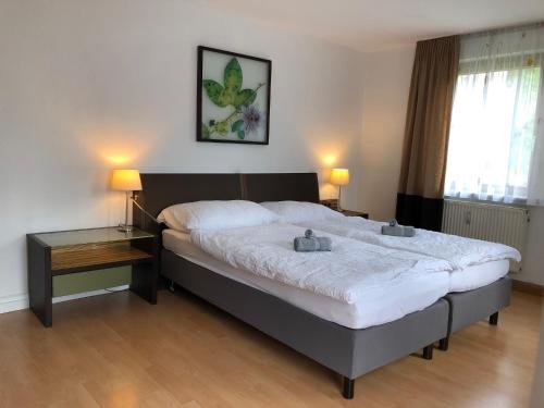 a bedroom with a large bed with two lamps on it at Große Wohnung mit 2 Schlafzimmern in Altensteig