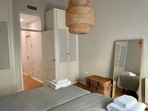 sypialnia z łóżkiem z lustrem i koszem w obiekcie 7R Charming Apartament Downtown Sevilla w Sewilli