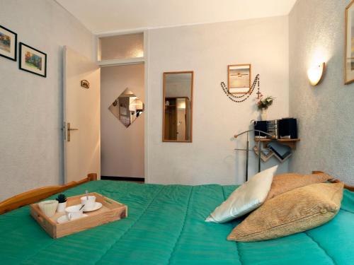 - une chambre avec un lit vert et un plateau en bois dans l'établissement Apartment Castel des Roches C4 by Interhome, à Saint-Gervais-les-Bains
