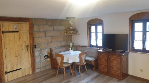 a dining room with a table with chairs and a tv at Das Ferienhaus Protze in Hohnstein