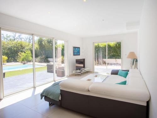 un grand lit dans une chambre avec une grande fenêtre dans l'établissement Villa Bastide de la Mer by Interhome, à Bormes-les-Mimosas