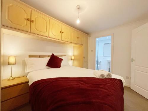 ein Schlafzimmer mit einem großen Bett mit einer roten Decke in der Unterkunft Cozy Nights SVP Detached House in Nitshill