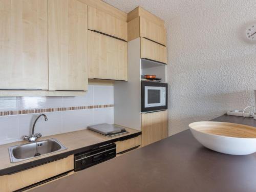 - une cuisine avec des placards en bois et un bol sur le comptoir dans l'établissement Apartment Les Pescadieres-4 by Interhome, au Lavandou