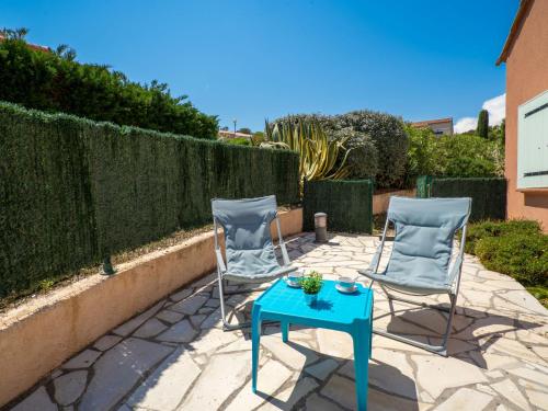 2 chaises et une table bleue sur une terrasse dans l'établissement Apartment Le Front de Mer-5 by Interhome, à Saint-Aygulf