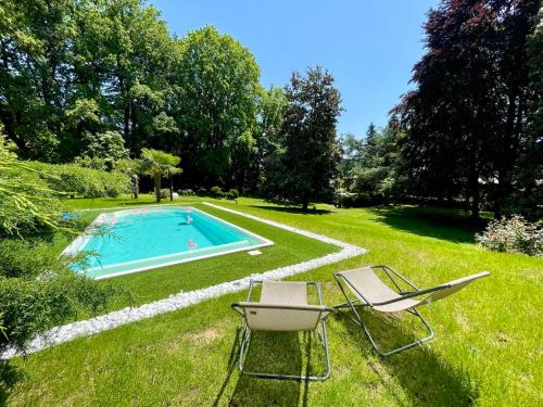een tuin met een zwembad en twee stoelen bij Villa Sofia by Interhome in Sirtori