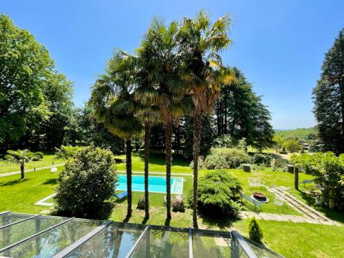 een glazen huis met palmbomen en een zwembad bij Villa Sofia by Interhome in Sirtori