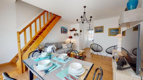 uma sala de estar com uma mesa e um sofá em Oasis de Croix de Vie em Saint-Gilles-Croix-de-Vie