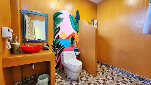 ein Badezimmer mit einem WC, einem Waschbecken und einem Spiegel in der Unterkunft พัทลุงเมริเดียนโฮเทล in Phatthalung