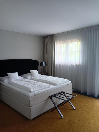a white bed in a room with a window at Pałac na Wodzie Hotel & SPA in Jelenia Góra