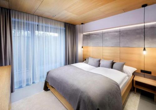 a bedroom with a large bed and a large window at Apartmány Horec in Tatranská Lomnica