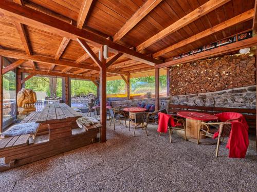 a pavilion with tables and chairs and a stone wall at Chalet Krakonoš by Interhome in Mladé Buky