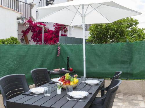 ein schwarzer Tisch mit einem Sonnenschirm und Obst darauf in der Unterkunft Holiday Home Peñismar II-1 by Interhome in Peñíscola