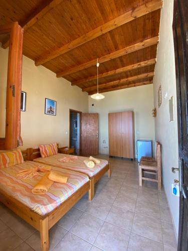 um quarto com uma cama grande e um tecto de madeira em Gavdos Panorama em Karave