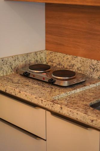 a kitchen counter with two burners on top of it at Costa Solar Lagoa in Florianópolis