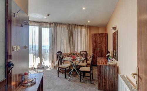 een keuken en eetkamer met een tafel en stoelen bij Ellinis Hotel in Varna