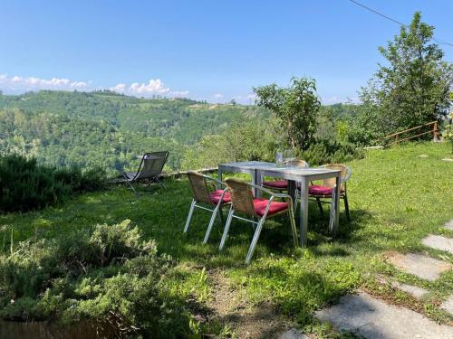 a table and chairs sitting in the grass at Apartment Casa Vacanza Cascina Lovera-1 by Interhome in Belvedere Langhe