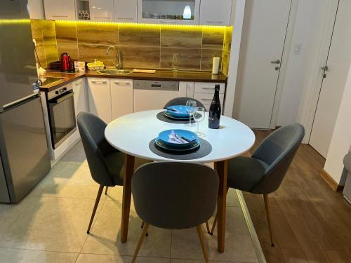 a kitchen with a table with chairs and a bottle of wine at Bamsae Belgrade in Vračar (historical)