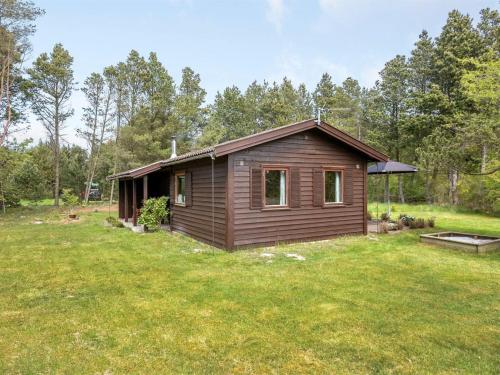 a small cabin in the middle of a yard at Holiday Home Carina - 5km from the sea by Interhome in Brovst