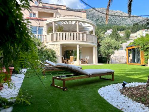 a house with a couch on the grass in the yard at Villa Romana II Omis in Omiš