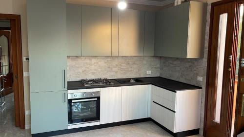 uma cozinha com armários brancos e um forno com placa de fogão em Casa Dolce Casa - Appartamento a Porto Viro em Porto Viro