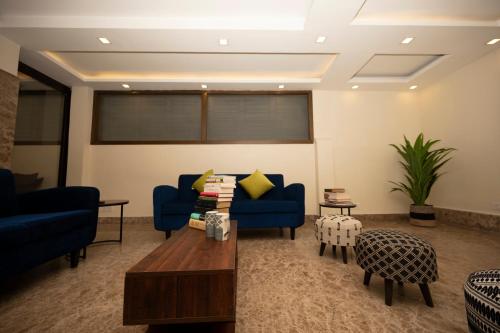 a living room with two blue couches and a table at Lakeside Suites in Kolkata