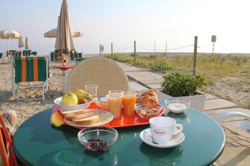 セニガッリアにあるHotel Atlanticのビーチでの朝食用の食材をトレイに添えたテーブル