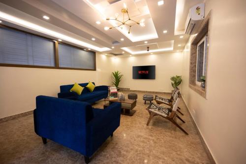 a living room with a blue couch and a table at Lakeside Suites in Kolkata