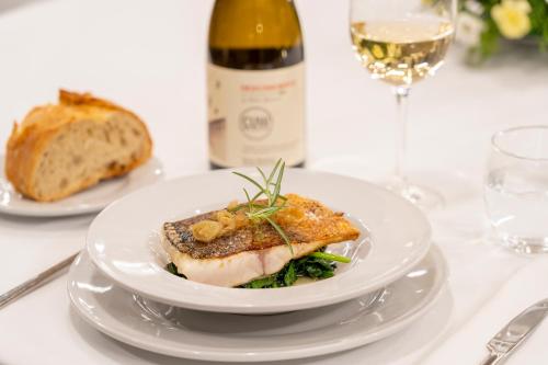 a plate of food on a table with a bottle of wine at Iberik Gran Balneario de Guitiriz in Guitiriz
