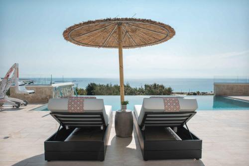 2 sedie sotto un ombrellone accanto alla piscina di Actea Seaview Villas I Free heated pool & 800m sea a Kíssamos