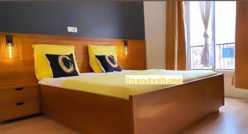 a bedroom with a large bed with yellow pillows at Nandy's home in Odza II
