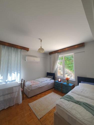 1 dormitorio con 2 camas y ventana en شقة اطلالة كاملة على مدينة بورصة مع مسبح وسط المدينة en Çekirge