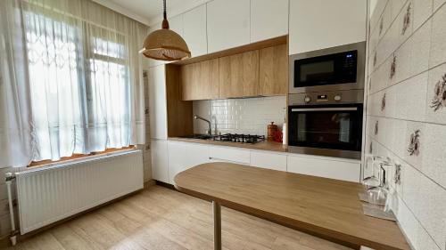 a kitchen with a wooden table in a room at Guest House Kartuli Suli in Tʼelavi