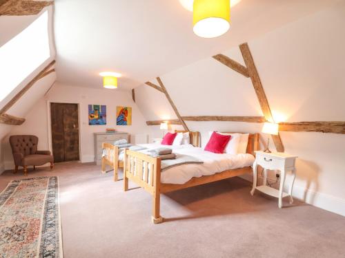 a bedroom with a bed and two tables in a attic at South Grange House in Sibton