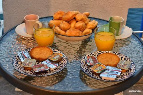 a glass table topped with bowls of food and orange juice at Sisi seaview apartments in Sissi